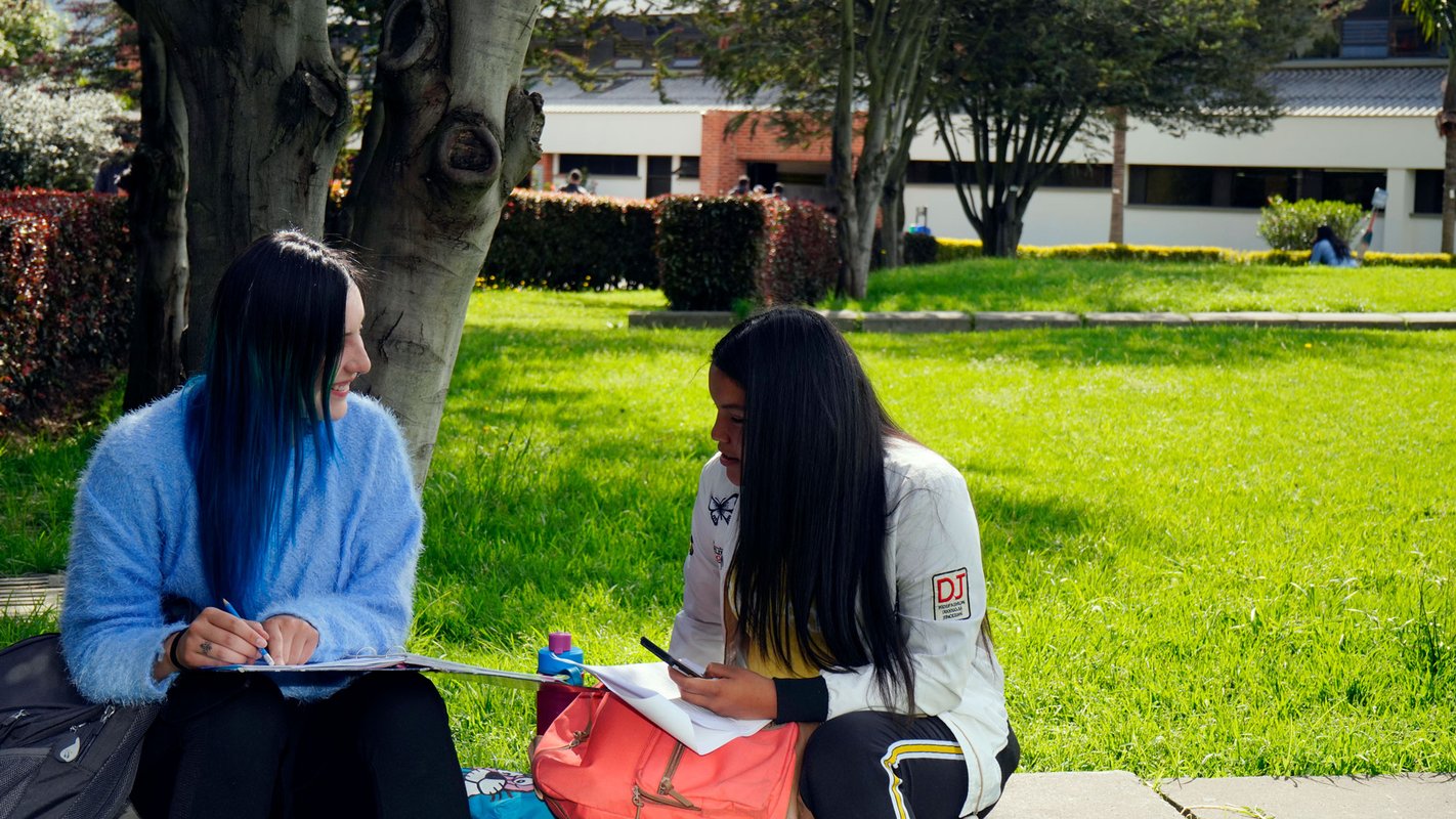 Estudiantes-compartiendo-cerca-a-la-biblioteca-en-las-zonas-verdes-del-campus-universitario.jpg