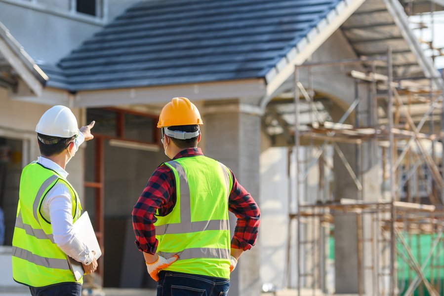 Ingeniero de construcción habla con el arquitecto en el lugar de construcción