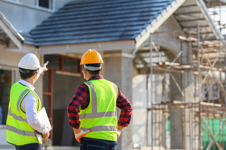 Ingeniero de construcción habla con el arquitecto en el lugar de construcción