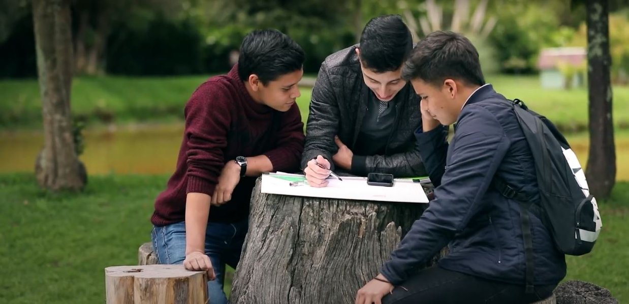 Tres estudiantes en el campus frente al lago.JPG