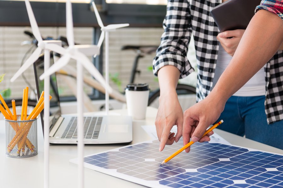ingeniero de energía alternativa que señala a un panel de energía solar