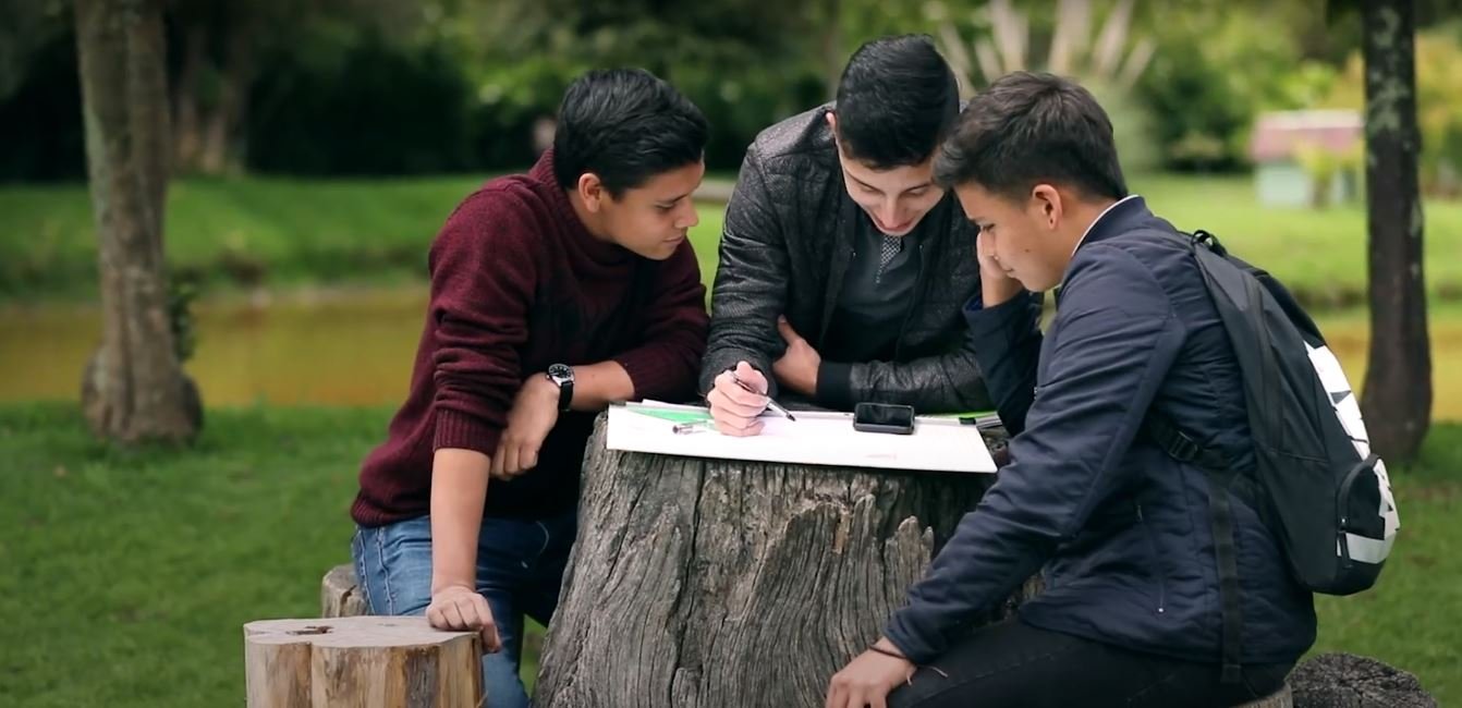 Tres estudiantes en el campus frente al lago.JPG